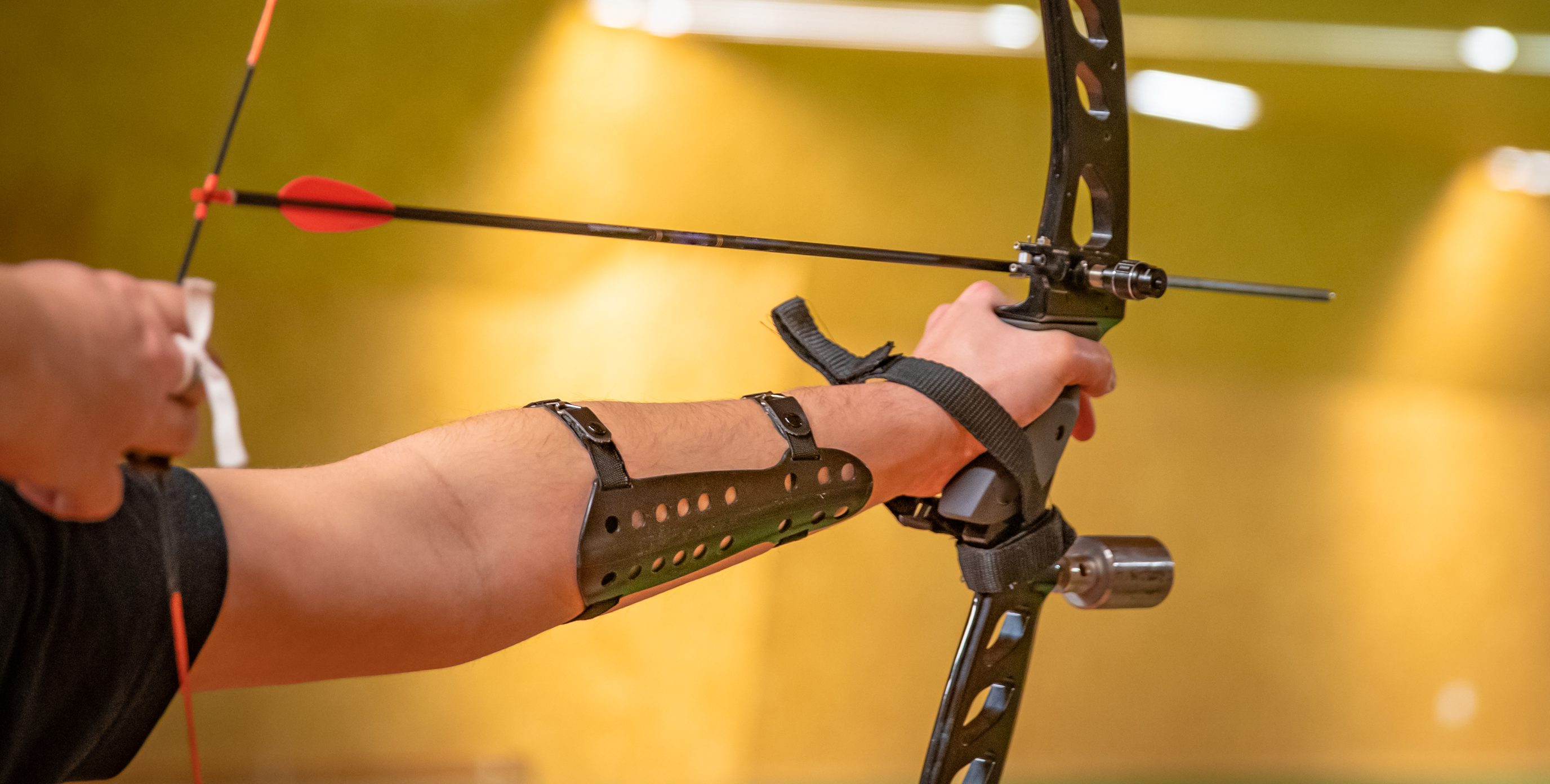 close-up in-motion image of an archer taking aim at a target in the distance